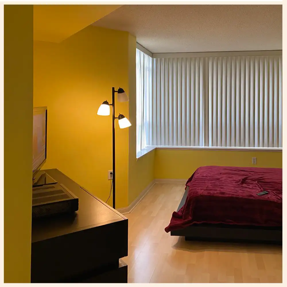 Yellow painted walls in bedroom with a red bed
